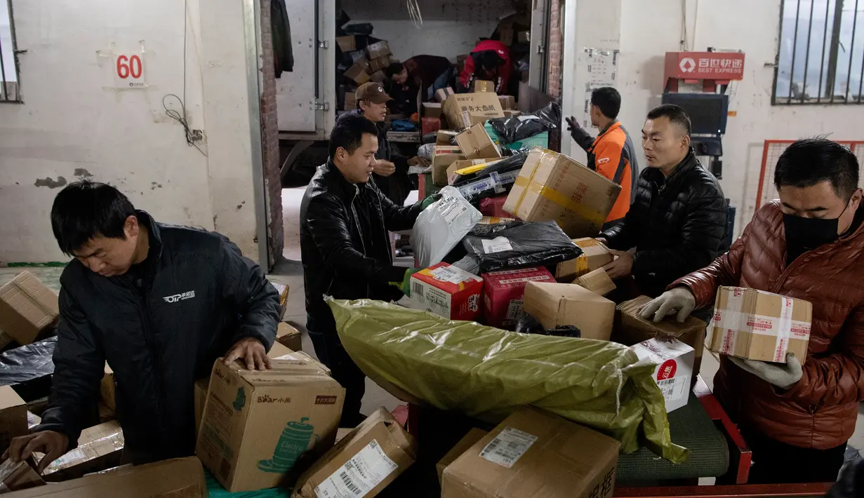 Para pekerja ekspedisi sibuk memilah paket untuk dikirim ke pelanggan saat Singles Day di Beijing, China, Senin (11/11/2019). Singles Day menjadi pesta belanja online terbesar di dunia. (NOEL CELIS/AFP)