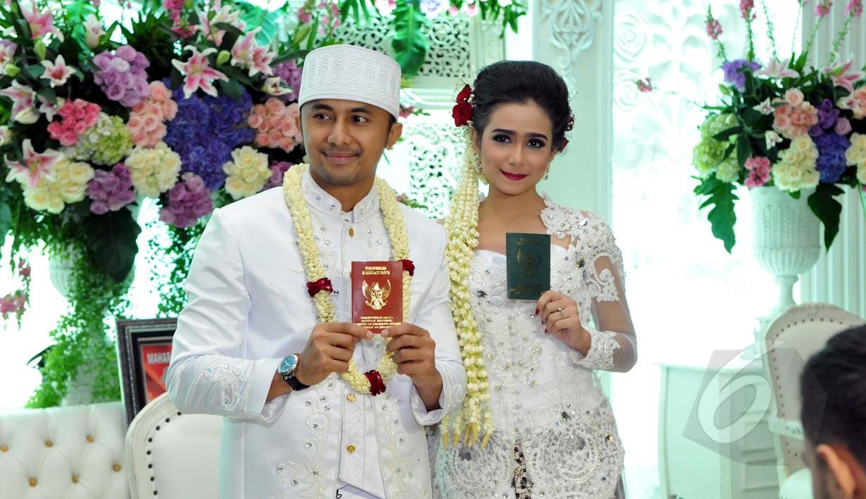 Hengky Kurniawan dan Sonya Fatmala menunjukan buku nikah seusai prosesi akad nikah di sebuah hotel kawasan TMII, Jakarta, Kamis (23/4/2015). (Liputan6.com/Panji Diksana)