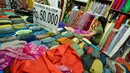 Pekerja merapikan kain lokal di Pasar Baru, Jakarta, Selasa (24/3/2015). Pengusaha tekstil nasional meminta Presiden Jokowi untuk melakukan kerja sama dengan Uni Eropa dan Turki agar bisa meningkatkan ekspor tekstil nasional.(Liputan6.com/Faizal Fanani)
