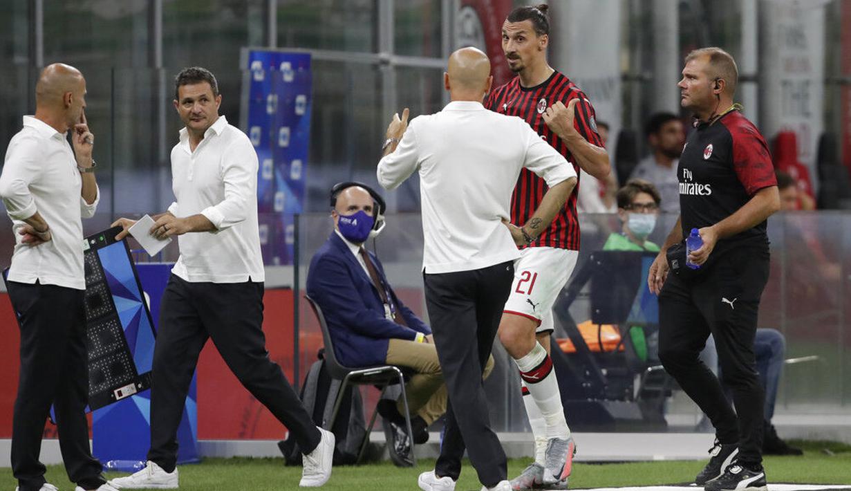Pelatih AC Milan, Stefano Pioli, berusaha menenangkan Zlatan Ibrahimovic yang kecewa usai diganti saat melawan Bologna pada laga Serie A di Stadion San Siro, Sabtu (18/7/2020). AC Milan menang dengan 5-1 atas Bologna. (AP/Luca Bruno)