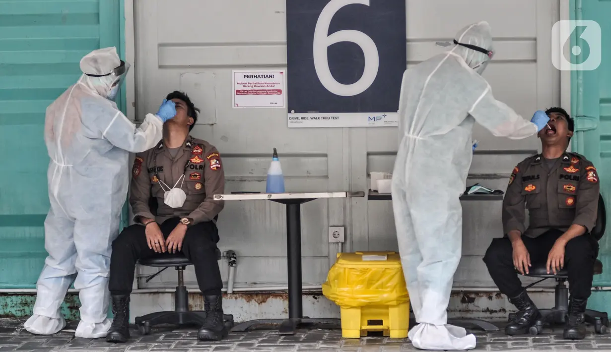 Petugas kesehatan melakukan swab test PCR pada personel polisi di Laboratoriun GSI Cilandak, Jakarta Selatan, Rabu (18/8/2021). Pemerintah melalui Kementerian Kesehatan resmi menetapkan tarif tertinggi pemeriksaan Real Time Polymerase Chain Reaction (RT-PCR). (merdeka.com/Iqbal S. Nugroho)