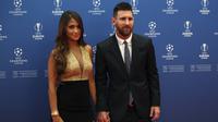 Penyerang Barcelona, Lionel Messi bersama istrinya Antonella Roccuzzo berpose saat tiba menghadiri acara undian penyisihan grup Liga Champions UEFA dan pemain terbaik Eropa di Forum Grimaldi, Monaco (29/8/2019). (AP Photo/Daniel Cole)