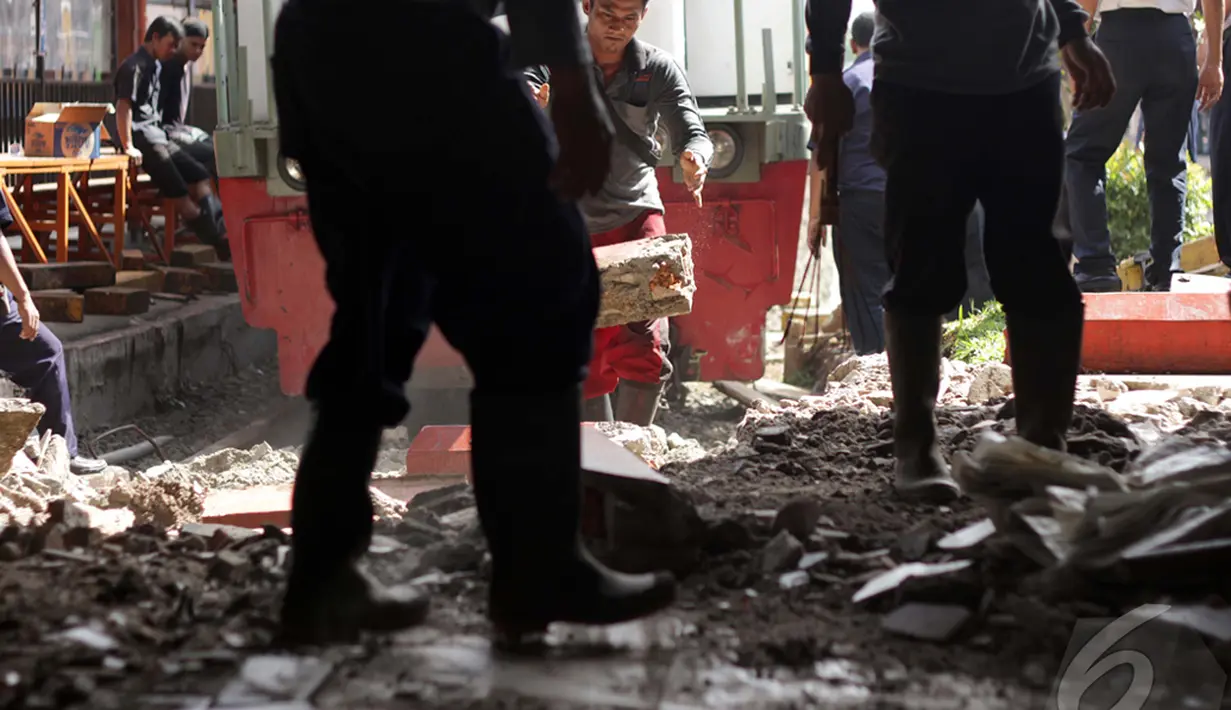 Petugas berusaha menarik lokomotif yang menabrak peron di Stasiun Kota, Jakarta, Jumat (26/12/2014). (Liputan6.com/Faizal Fanani)