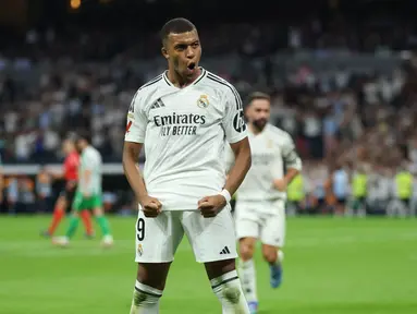Penyerang Real Madrid Prancis #09 Kylian Mbappe merayakan gol kedua timya dari titik penalti saat menjamu Real Betis pada pekan keempat La Liga 2024/2025 di Santiago Bernabeu, Senin (02/09/2024) dini hari WIB. (Thomas COEX / AFP)