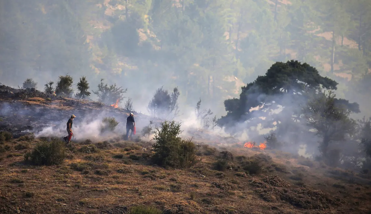 Relawan memadamkan api saat kebakaran hutan di Koycegiz, Mugla, Turki, Senin (9/8/2021). Kebakaran hutan yang terjadi di tengah gelombang panas ganas telah berkobar selama berhari-hari di lebih dari setengah provinsi Turki. (AP Photo/Emre Tazegul)