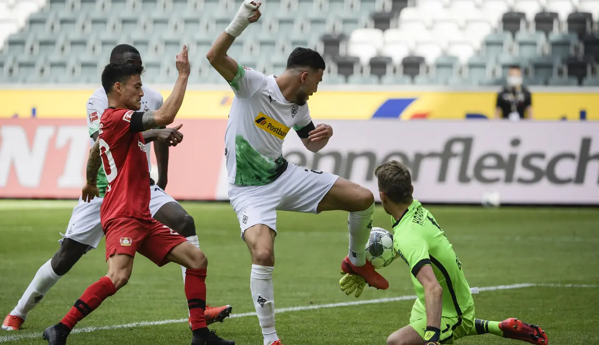 Pemain Bayer Leverkusen, Charles Mariano Aranguiz, berusaha melewati pemain Borussia Moenchengladbach pada laga Bundesliga, Minggu (24/5/2020). Bayer Leverkusen menang 3-1 atas Borussia Moenchengladbach. (AFP/Ina Fassbender)
