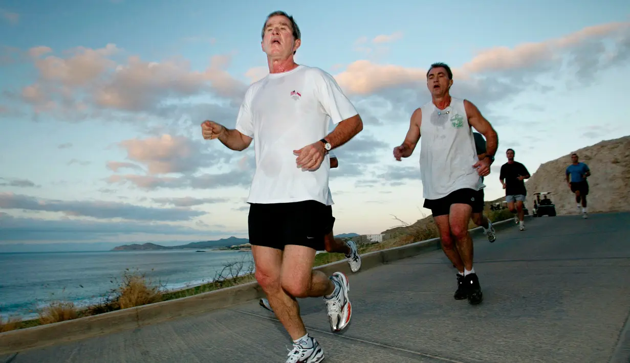 Mantan Presiden AS, Presiden AS George W. Bush saat berlari pagi bersama dengan US Secret Service Agen pada 27 Oktober 2002. Saat menjadi presiden dia berlari enam hari dalam sepekan. Dia bahkan punya treadmill di Air Force One. (AFP PHOTO/Stephen Jaffe)