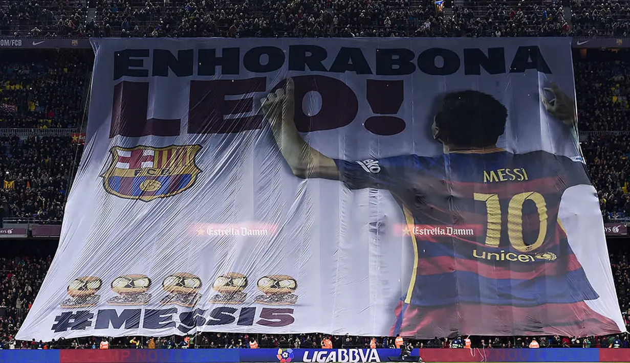 Para supporter Barcelona memberikan ucapan selamat kepada Lionel Messi usai meraih Ballon d'Or jelang laga melawan Athletic Bilbao. Tulisan di spanduk itu memiliki arti "Selamat Leo". (AFP/Josep Lago)