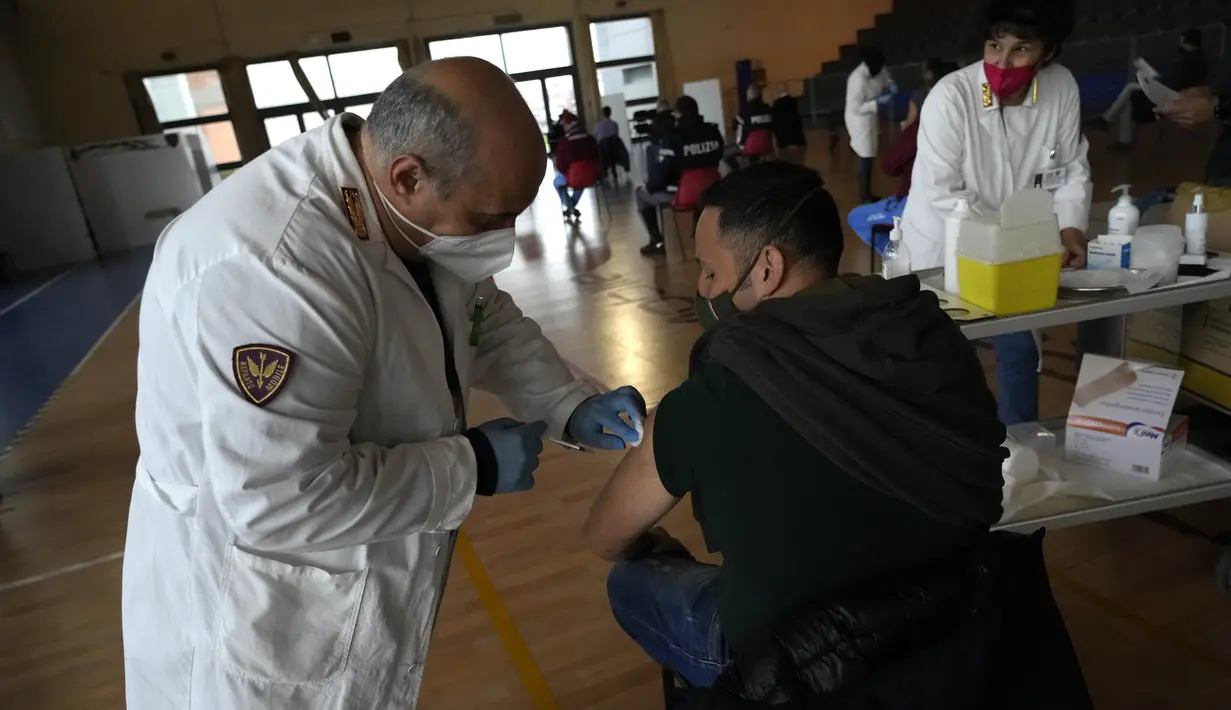 Petugas kepolisian Italia mendapatkan suntikan vaksin COVID-19 di pusat vaksinasi yang terletak di gym barak polisi di Roma, Jumat (10/12/2021). Pemerintah Italia telah mewajibkan vaksinasi COVID-19 bagi anggota polisi mulai 15 Desember mendatang. (AP Photo/Alessandra Tarantino)