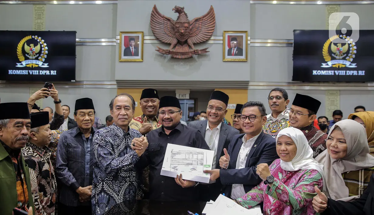 Ketua Komisi VIII DPR RI, Ashabul Kahfi (keempat kiri) bersalaman dengan Menteri Agama Yaqut Cholil Qoumas (tengah) seusai menandatangani draft penetapan biaya haji 2023 di kompleks Parlemen, Senayan, Jakarta, Rabu (15/2/2023). Kementerian Agama bersama Komisi VIII DPR selesai menggelar rapat panja biaya haji 2023. Pemerintah bersama legislator menyepakati biaya haji yang harus dibayarkan jemaah sebesar Rp 49.812.700. (Liputan6.com/Faizal Fanani)