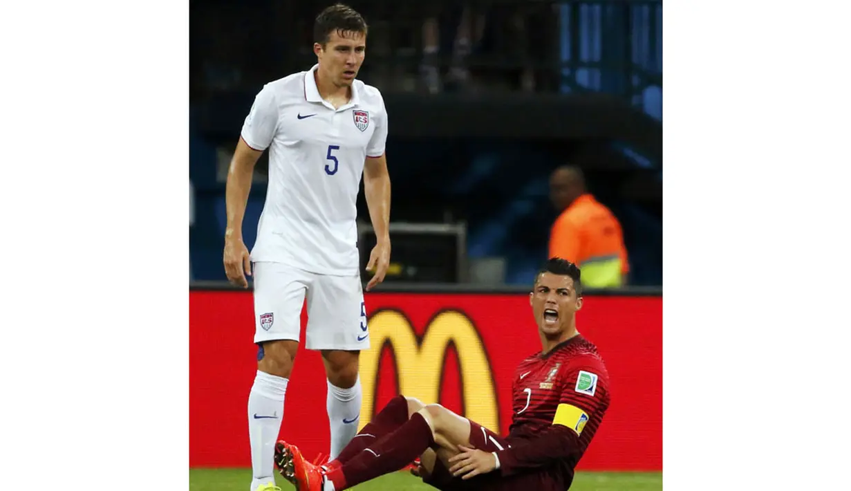 Pemain depan Portugal, Cristiano Ronaldo (kanan) berteriak usai dilanggar pemain belakang AS, Matt Besler, saat berlaga di penyisihan Piala Dunia 2014 Grup G di Stadion Amazonia, Manaus, Brasil, (23/6/2014). (REUTERS/Jorge Silva)