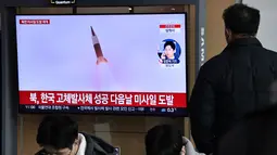 Seorang pria menonton layar televisi yang menayangkan siaran berita dengan rekaman file uji coba rudal Korea Utara, di sebuah stasiun kereta api di Seoul, Sabtu (31/12/20220). Ketiga rudal balistik jarak dekat itu dilaporkan jatuh ke perairan sebelah timur Semenanjung Korea. (Jung Yeon-je / AFP)