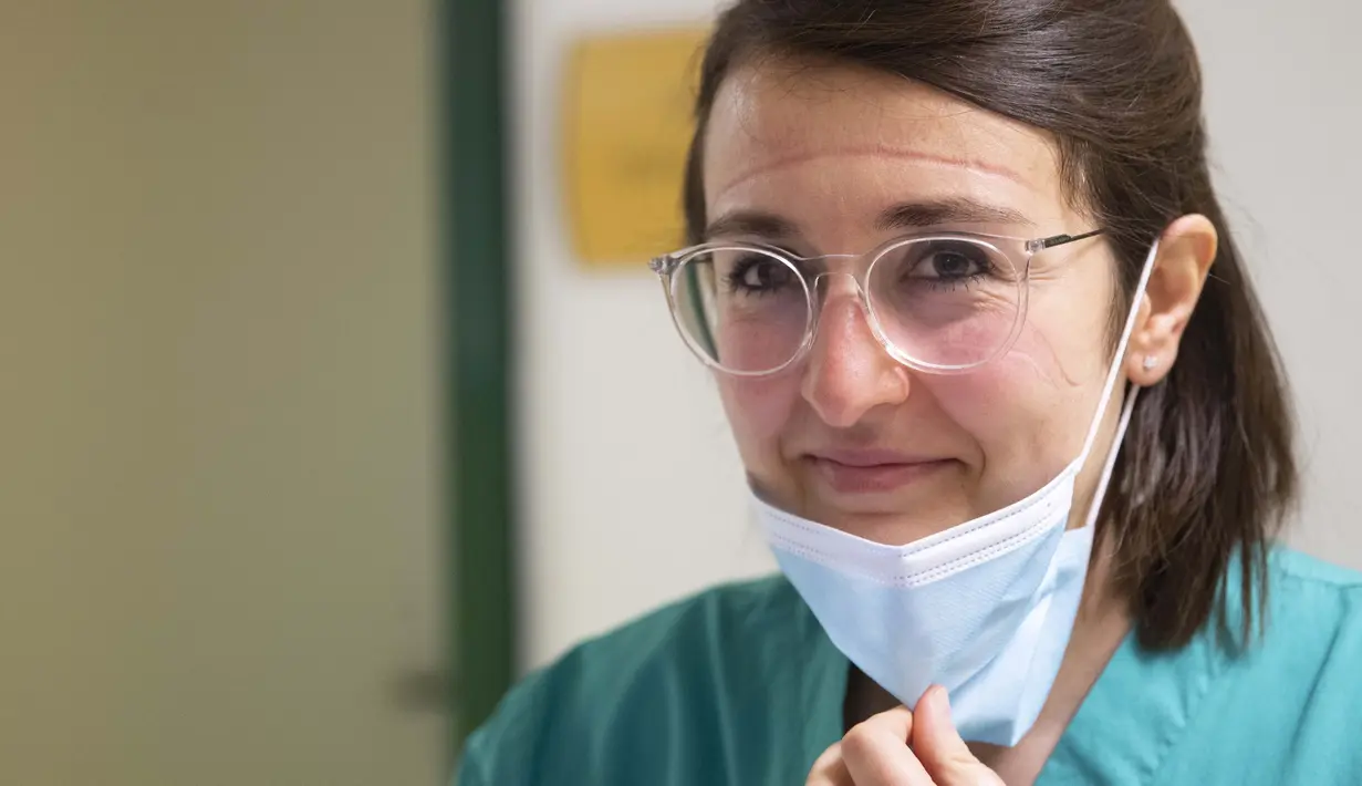 Elisabetta Teti, dengan bekas luka yang dalam di wajah saat memakai masker, tersenyum pada akhir pemeriksaan medis di unit sub-intensif COVID-19 Rumah Sakit Poliklinik Tor Vergata, di Roma , 7 November 2020. (AP Photo/Alessandra Tarantino)