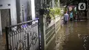 Warga berjalan menerjang banjir karena hujan di Jalan Shofa Marwah, Jakarta, Jumat (4/11/2022). Berdasarkan laporan Badan Penanggulangan Bencana Daerah (BPBD) DKI Jakarta yang diperbaharui pada pukul 18.00 WIB, terdapat 4 RT yang terendam banjir dengan ketinggian maksimal mencapai 50 Cm. (Liputan6.com/Faizal Fanani)