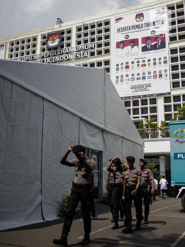 Sejumlah persenel kepolisian berjalan saat mengamankan Kantor Komisi Pemilihan Umum (KPU), Jakarta, Kamis (18/4). Hal tersebut dilakukan untuk mengantisipasi ancaman keamanan usai Pemilu 2019. (Liputan6.com/Faizal Fanani)