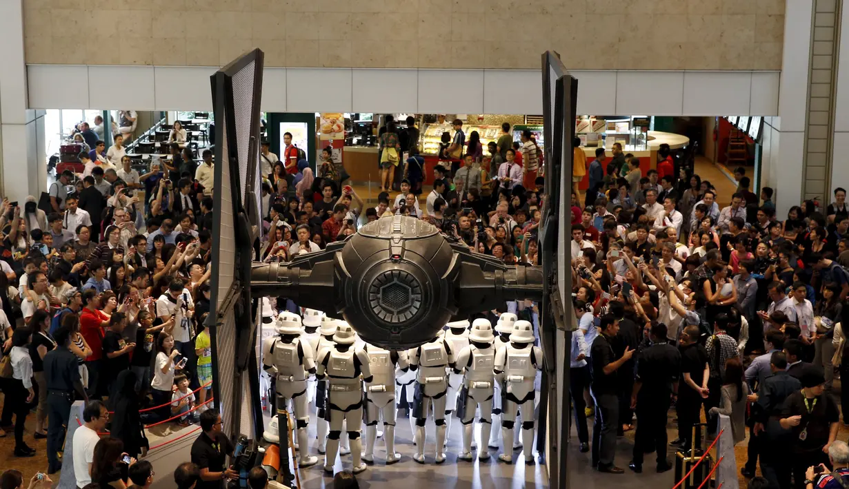 Pengunjung mengabadikan gambar para Stormtroopers dengan pesawat perangnya  di Bandara Changi, Singapura, Kamis (12/11/2015). Acara ini bertepatan dengan tur media Star Wars bertema All Nippon Airways ANA R2D2 Boeing 787. (REUTERS/Edgar Su) 