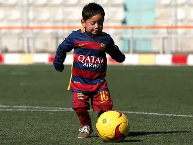 Murtaza Ahmadi (5) memakai jersey Barcelona bernama Messi saat bermain sepak bola di markas Federasi Sepak Bola Afghanistan di Kabul , Afghanistan, (2/2). Bintang Barcelona Lionel Messi dikabarkan akan bertemu dengan bocah ini. (REUTERS / Omar Sobhani)