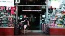 Seorang pemilik toko duduk di luar tokonya selama pemadaman listrik di Times Square, New York, AS, Sabtu (13/7/2019).  Pemadaman listrik juga mempengaruhi bagian barat Manhattan, khususnya kawasan Hell's Kitchen dan teater Broadway. (AP Photo/Michael Owens)
