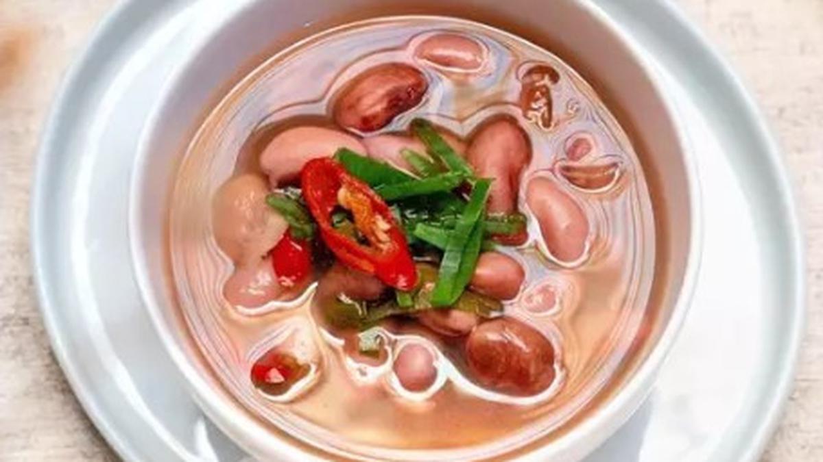 Semangkuk sayur asam kacang merah segar dengan potongan jagung, labu siam, dan kacang panjang, disajikan hangat dengan kuah bening yang menggugah selera