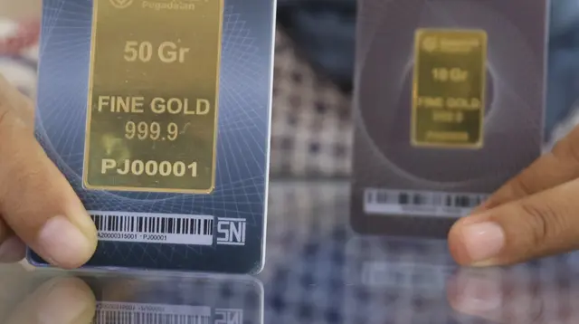 Petugas memperihatkan emas batangan yang dijual di Galeri 24 Pegadaian, Jakarta, Jumat (25/3/2022). Harga emas Antam di Pegadaian kembali naik. Hari ini harga emas Antam naik Rp 6.000 menjadi Rp 1 juta per gram, pada 25 Maret 2022. (Liputan6.com/Angga Yuniar)