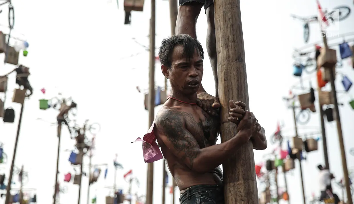 Ekspresi warga mengikuti panjat pinang Kolosal dalam rangka merayakan HUT ke 72 RI di Pantai Karnaval Ancol, Jakarta, Kamis (17/8). Sebanyak 172 batang pohon pinang disediakan untuk warga dengan berbagai macam hadiah menarik. (Liputan6.com/Faizal Fanani)
