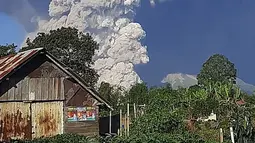 Gunung Sinabung menyemburkan abu ke langit, terlihat dari Karo, Sumatera Utara, Selasa (2/3/2021).   Guguran awan panas tersebut meluncur ke arah timur tenggara dengan jarak luncur 3 kilometer. (AFP/Bahari Tarigan)