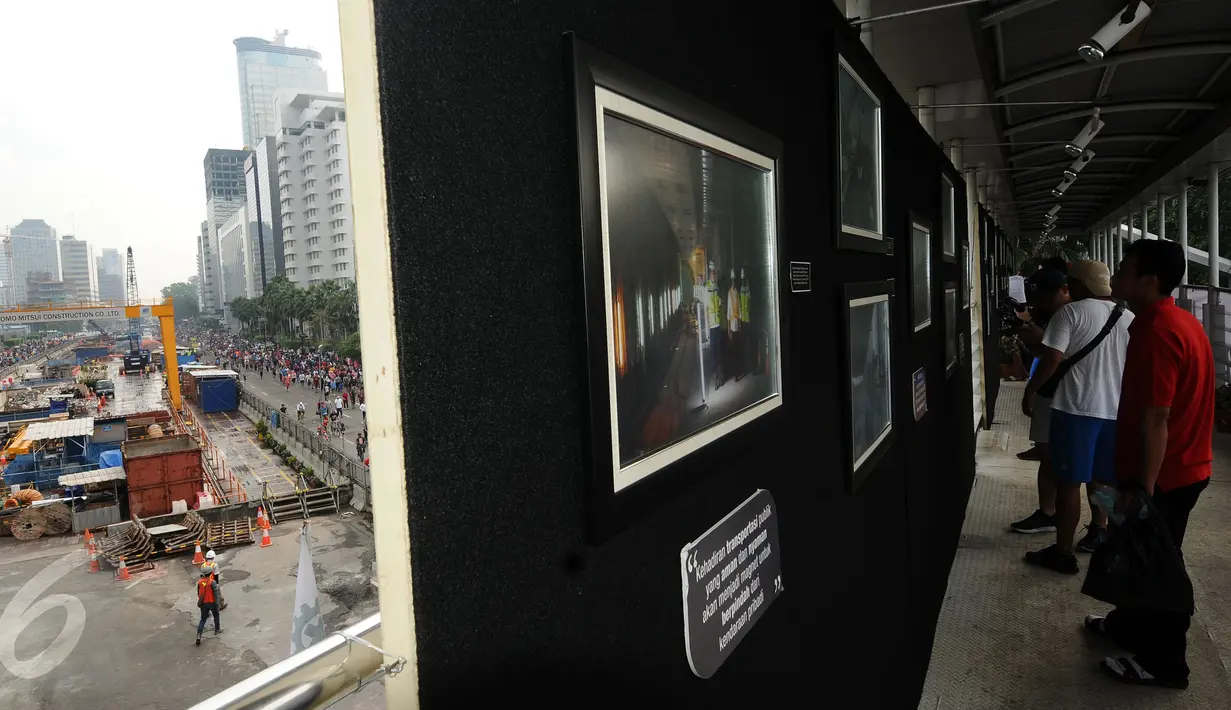 Warga melihat pameran foto kemajuan pembangunan MRT di Jembatan Penyebrangan Orang Bundaran Hotel Indonesia, Jakarta, Minggu (7/5). Pameran bertema Aku, Kamu, Kita #UbahJakarta. (Liputan6.com/Helmi Fithriansyah)