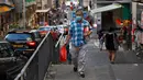 Seorang pria yang mengenakan masker berjalan di sepanjang jalan di Hong Kong, Rabu (22/7/2020). Hong Kong menghadapi "tahap kritis" dalam perjuangannya melawan COVID-19, dan pemerintah sedang memperpanjang langkah-langkah baru untuk menjaga jarak sosial. (AP Photo/Kin Cheung)