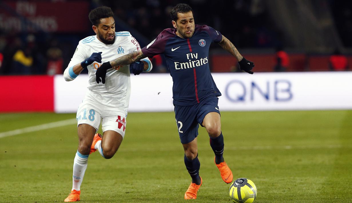 Pemain PSG, Dani Alves (kanan) berebut bola dengan pemain Marseille, Jordan Amavi pada lanjutan Ligue 1 Prancis di Parc des Princes Stadium, Paris, (25/2/2018). PSG menang 3-0. (AP/Thibault Camus)