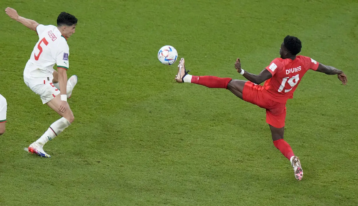 <p>Bek Kanada, Alphonso Davies berebut bola dengan pemain Maroko, Nayef Aguerd selama pertandingan grup F Piala Dunia 2022 di Stadion Al Thumama di Doha, Qatar, Kamis (1/12/2022). Maroko menang tipis atas Kanada dengan skor 2-1. (AP Photo/Alessandra Tarantino)</p>