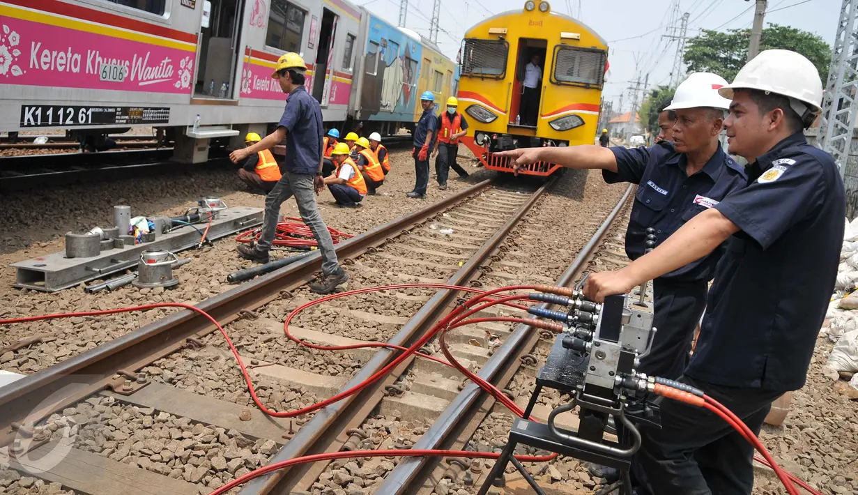 Petugas mengevakuasi gerbong kereta yang anjlok di jalur kereta api manggarai, Jakarta, Selasa (27/10/2015). PT KAI Commuter Jabodetabek menyampaikan permintaan maaf atas insiden anjloknya KA 1347 di Stasiun Manggarai. (Liputan6.com/Gempur M Surya)