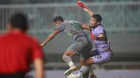 Kiper Persikabo 1973, Mochamad Diky Indriyana (kanan) berduel udara dengan pemain Persebaya Surabaya, Rizky Ridho Ramamadhani dalam laga pekan pertama BRI Liga 1 2022/2023 antara Persikabo 1973 melawan Persebaya Surabaya di Stadion Pakansari, Bogor, Senin (25/7/2022) malam WIB. (Bola.com/M Iqbal Ichsan)