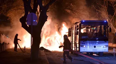 Petugas pemadam bersiap memadamkan api setelah ledakan bom mobil di Ankara, Turki, Rabu (17/2). Bom mobil yang meledak ketika iring-iringan bus militer tengah lewat tersebut menewaskan setidaknya 28 orang.  (REUTERS/Ihlas News Agency TURKEY OUT)