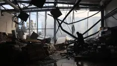 Seorang karyawan toko kelontong, yang hancur akibat serangan rudal Rusia, mengumpulkan barang-barang di Kostyantynivka, wilayah Donetsk, pada 25 Februari 2024. (Anatolii STEPANOV/AFP)