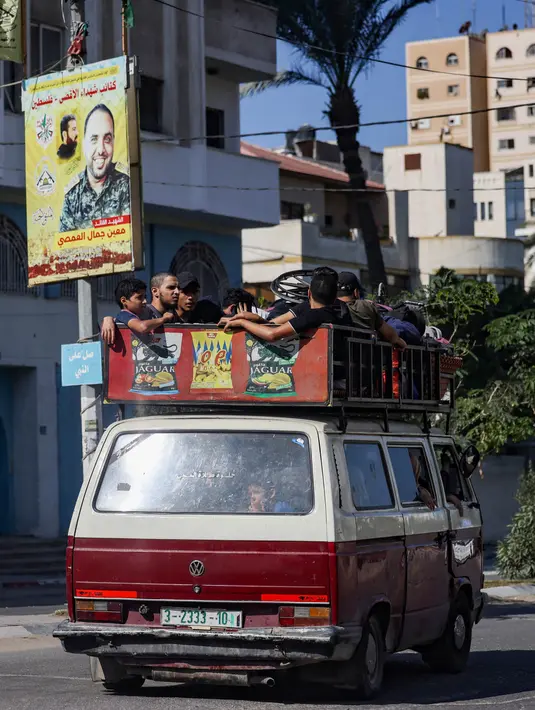 Menggunakan kendaraan seadanya, warga meninggalkan kota Gaza. (MOHAMMED ABED/AFP)