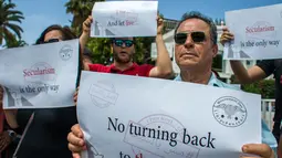 Seorang demonstran Tunisia saat melakukan aksi unjuk rasa protes terhadap pemilik restoran dan bar yang menutup tokonya selama puasa bulan suci Ramadan di Tunis, Tunisia, (27/5). (AP Photo / Hassene Dridi)