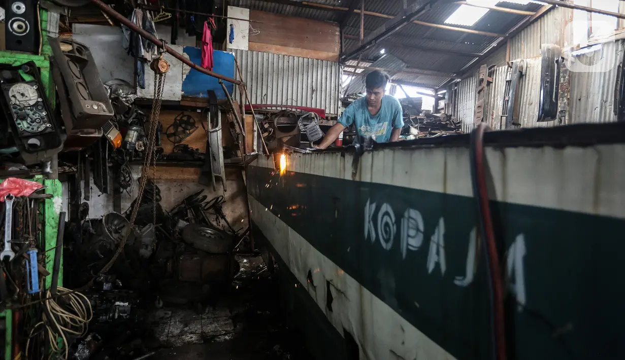 Pekerja membongkar Koperasi Angkutan Jakarta (Kopaja) yang akan diremajakan di kawasan Meruya, Jakarta Barat, Rabu (27/1/2021). Kopaja yang tak lagi digunakan tersebut dihancurkan untuk dijual secara kiloan ke penjual besi tua. (Liputan6.com/Johan Tallo)