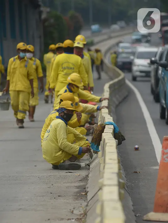 Sejumlah petugas melakukan pengecetan separator jalur busway imbas unjuk rasa menolak Omnibus Law UU Cipta Kerja di Jalan M.H. Thamrin, Jakarta, Sabtu (10/10/2020). Wagub DKI Jakarta Ahmad Riza Patria memperkirakan kerugian imbas ujuk rasa tersebut mencapai Rp.65 miliar. (merdeka.com/Imam Buhori)