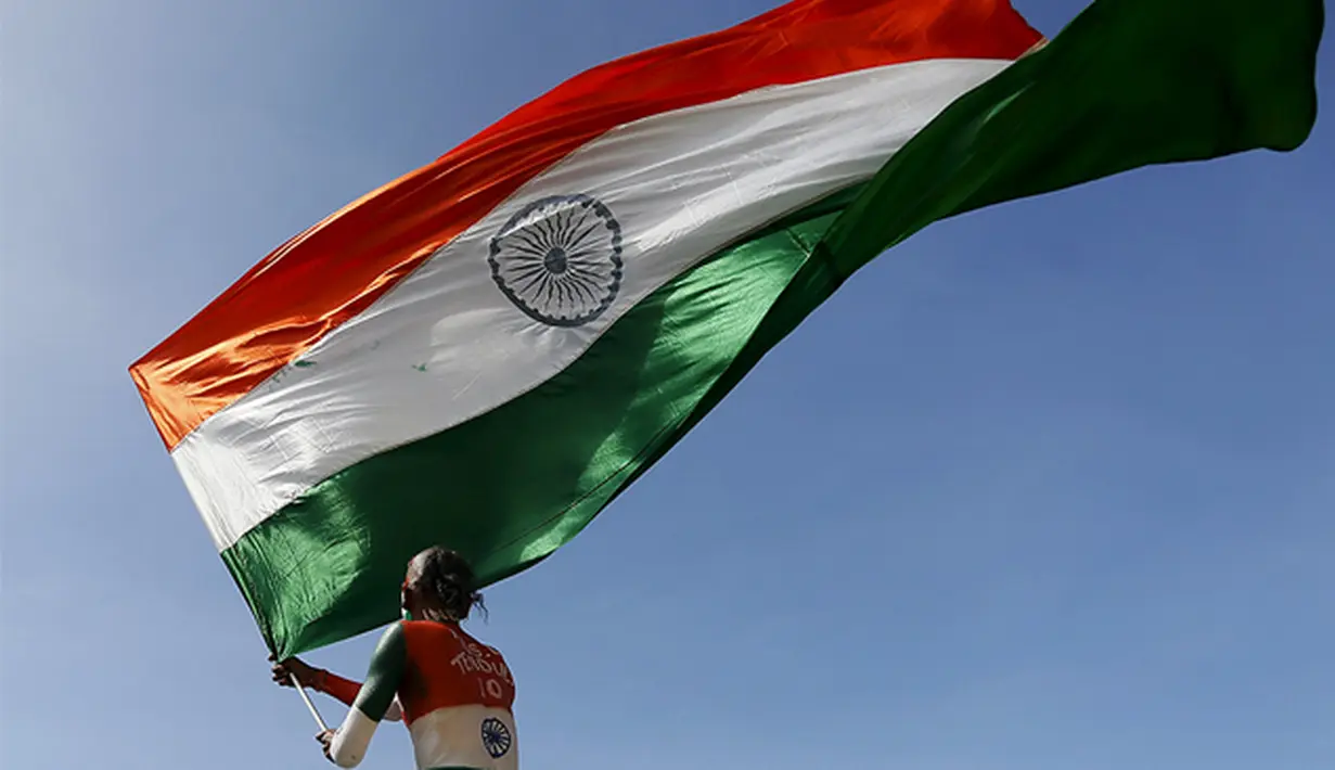 Supporter tim kriket India mengibarkan bendera kebangsaannya saat pertandingan melawan Sri Lanka di Galle, Sri Lanka, Kamis (13/8/2015). (Reuters/Dinuka Liyanawatte)