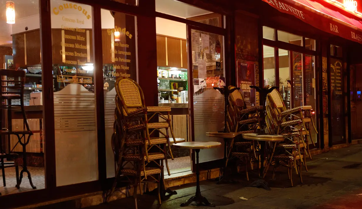 Tumpukan kursi di luar bar yang tutup di Paris di tengah langkah-langkah baru untuk memerangi penyebaran cepat Covid-19 pada Senin (5/10/2020). Seluruh bar dan kafe di Paris – yang diberlakukan siaga maksimum Covid-19 – ditutup selama dua pekan, yang dimulai 6 Oktober. (GEOFFROY VAN DER HASSELT/AFP)
