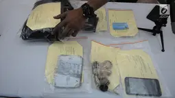 Petugas merapikan barang bukti saat rilis pengungkapan kasus penjambretan di Polda Metro Jaya, Jakarta, Senin (8/4). Penjambretan itu terjadi pada Jumat (5/4) pukul 02.00 WIB. (Liputan6.com/Herman Zakharia)