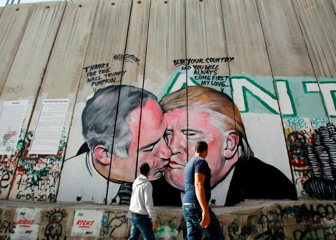 Mural Presiden AS Donald Trump berciuman dengan PM Israel Benjamin Netanyahu di tembok pembatas di Tepi Barat Yerusalem. Mural tersebut karya seniman Australia, Lushux (AFP/Musa Al Shaer)