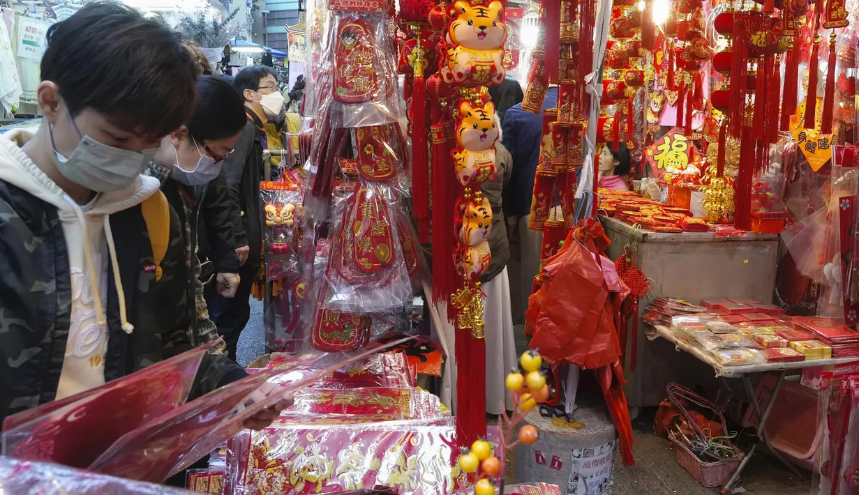 Orang-orang membeli dekorasi untuk merayakan Tahun Baru Imlek di Hong Kong, Minggu (30/1/2022). Tahun Baru China atau Imlek jatuh pada 1 Februari (AP Photo/Vincent Yu)