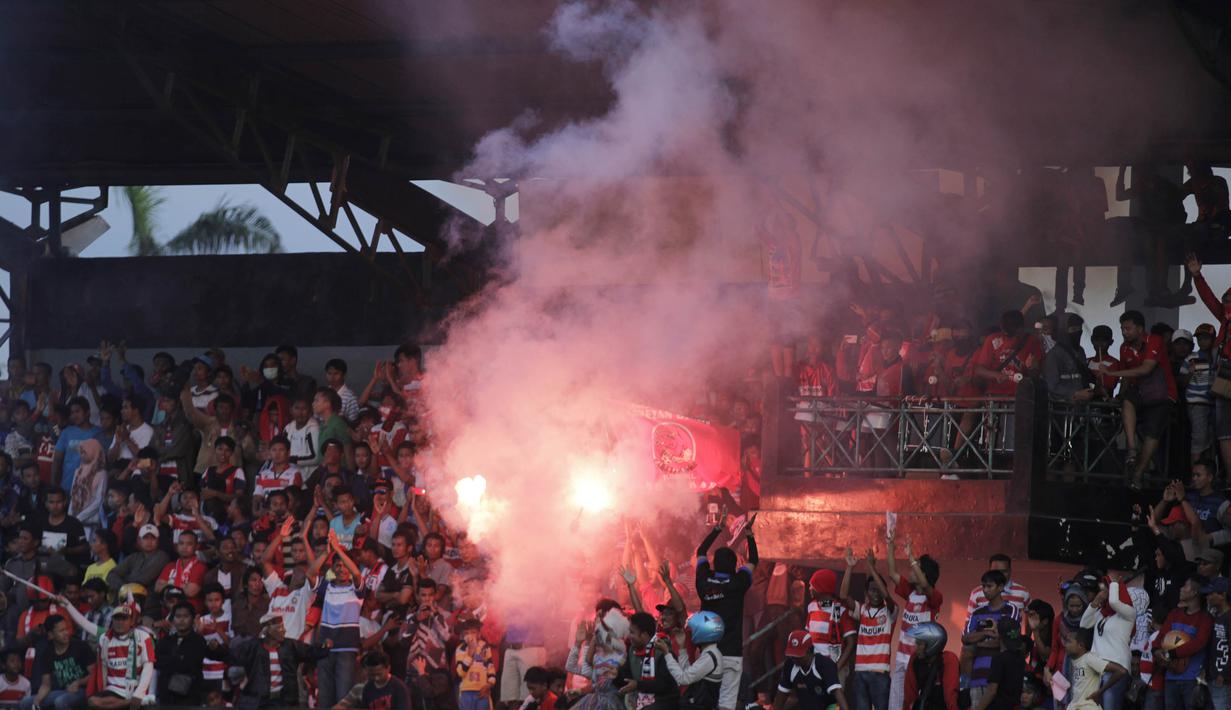 Para suporter menyalakan suar usai menyaksikan laga uji coba antara Madura United melawan Persiba Balikpapan. (Bola.com/Vitalis Yogi Trisna)