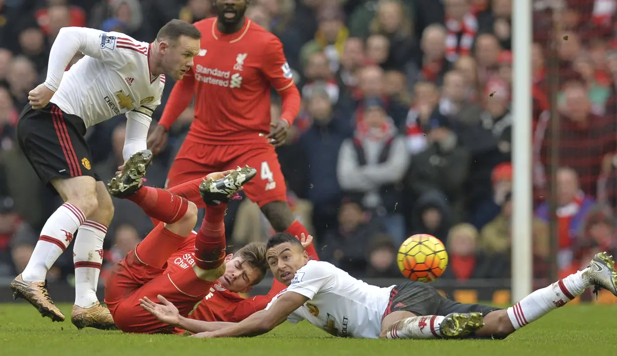 Pemain Manchester United, Wayne Rooney (kiri), dan Jesse Lingard (kanan) berebut bola dengan pemain Liverpool, Alberto Moreno (2kiri) pada lanjutan liga premier Inggris di Stadion Anfield,  Liverpool, Minggu (17/1/2016).  (AFP Photo/Paul Ellis)