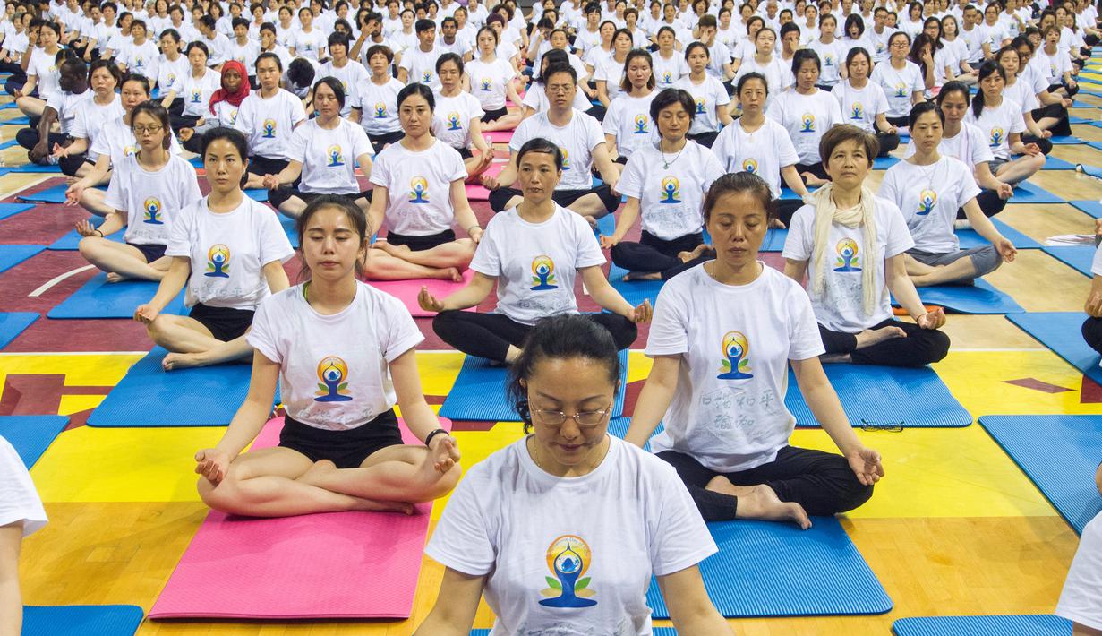 Sejumlah orang melakukan gerakan yoga di Zhenjiang, Provinsi Jiangsu, Cina, (20/6). Sejumlah negara di dunia sedang merayakan Hari Yoga Dunia yang jatuh pada tanggal 21 Juni. (REUTERS/Stringer)