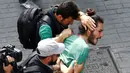 Polisi berpakaian preman menahan aktivis LGBT ketika mereka mencoba melancarkan pawai tahunan LGBTI, di Istanbul, Minggu (26/6). Satu pekan sebelumnya, pemerintah Turki telah mengeluarkan larangan menggelar pawai tahunan LGBTI. (REUTERS/Osman Orsal)