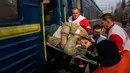 Pekerja Medecins Sans Frontieres (MSF) atau Doctors Without Border membawa seorang pria dengan tandu ke kereta medis MSF saat mengevakuasi pasien dari dekat garis depan pertempuran ke daerah yang lebih aman di stasiun kereta di Pokrovsk, Ukraina, 7 Maret 2023. MSF merupakan kereta medis khusus yang dapat membawa pasien dari bagian timur Ukraina ke rumah sakit di bagian barat. (AP Photo/Evgeniy Maloletka)