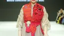 Menuju penghujung acara, muncul Nagita Slavina mengenakan vest ulos warna merah yang mencolok. Ibu 2 anak itu tampil sebagai model koleksi “Jatuh dan Cinta” milik desainer Surya Abduh. [Fimela/Bambang E. Ros]