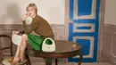 Dalam salah satu tampilannya, Gigi mengenakan crop knit top biru elektrik dengan rok hitam high-waist dan tas hijau Miu Miu matelassé yang menjadi statement utama. [Dok/Miu Miu].